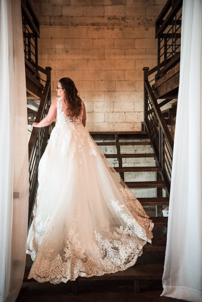 A Norman's bride shows off her train on a staircase.