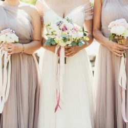 Closeup of bridal bouquets with bride in the middle and bridesmaids on the sides.