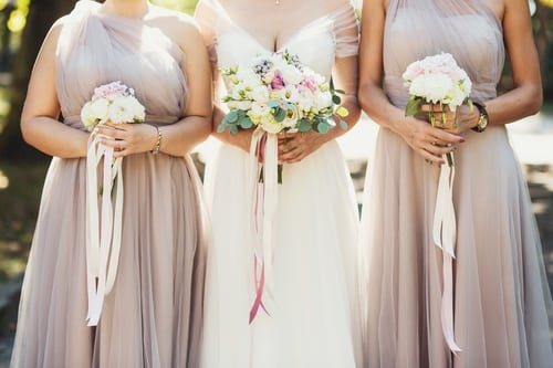 Closeup of bridal bouquets with bride in the middle and bridesmaids on the sides.