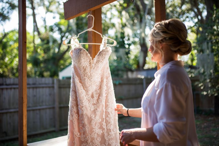 A Norman's bride admires her hanging wedding gown.