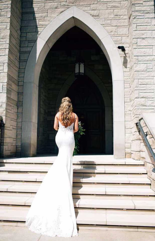 A Norman's bride shows off her train on the steps outside the church.
