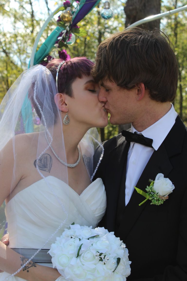 A Norman's bride and her groom share a kiss.