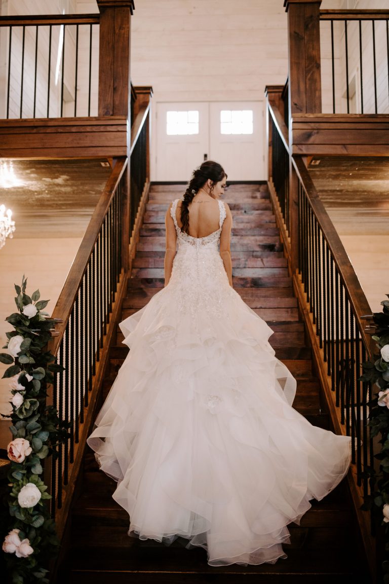 A Norman's bride on a staircase shows off her train.